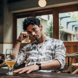 unhappy man sitting next to an almost empty beer glass